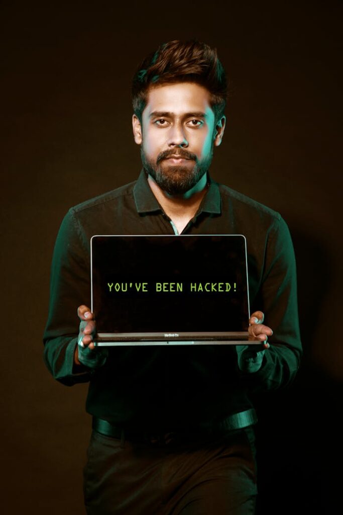 pexels photo 2036656 A man showing a laptop with a 'You've been hacked' message, symbolizing cyber security threats.