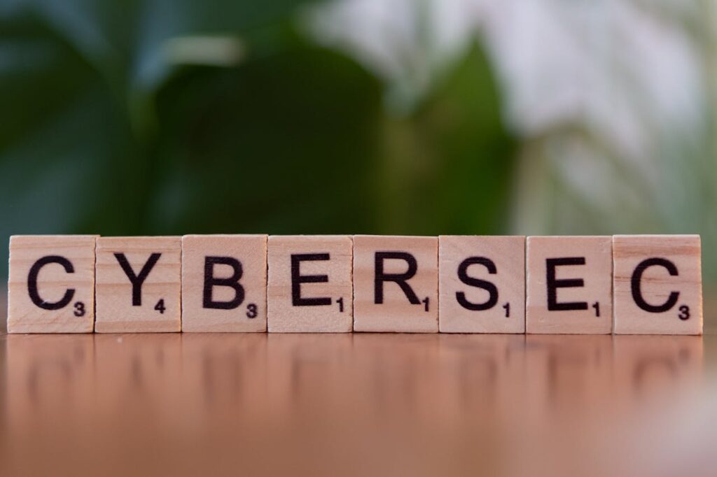 pexels photo 30901560 Wooden tiles spell 'CYBERSEC' against a soft-focused green background.